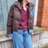 Doudoune marron à détails en jean, poche en jean sur le torse, finition en jean sur les poignets, et sur le bas de la doudoune.