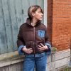 Doudoune marron à détails en jean, poche en jean sur le torse, finition en jean sur les poignets, et sur le bas de la doudoune.