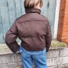 Doudoune marron à détails en jean, poche en jean sur le torse, finition en jean sur les poignets, et sur le bas de la doudoune.