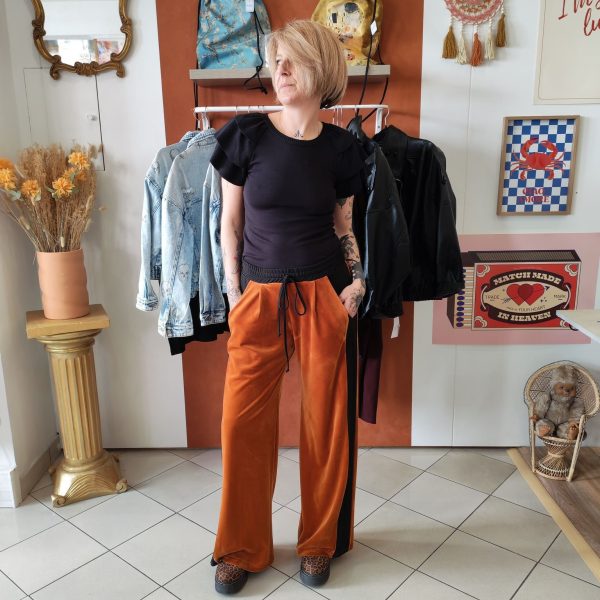 Pantalon velours orange vif avec ligne noir intense sur les côtés. 2 poches pratiques.