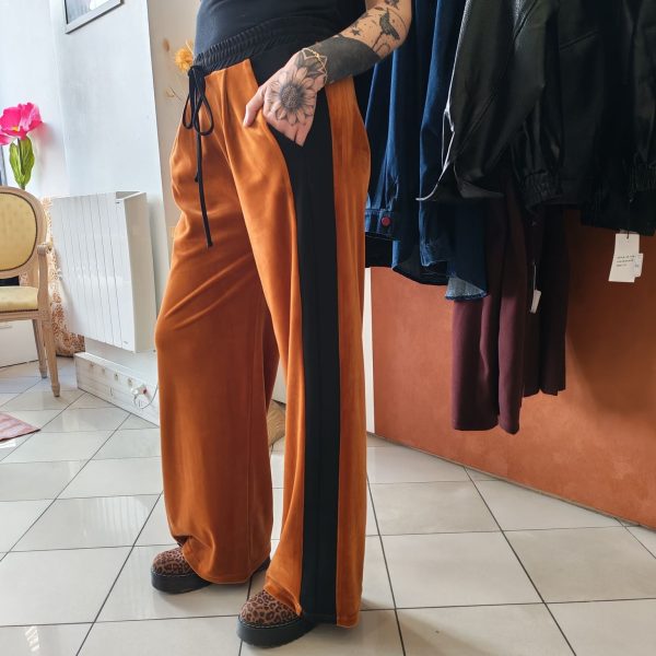 Pantalon velours orange vif avec ligne noir intense sur les côtés. 2 poches pratiques.