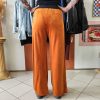 Pantalon velours orange vif avec ligne noir intense sur les côtés. 2 poches pratiques.