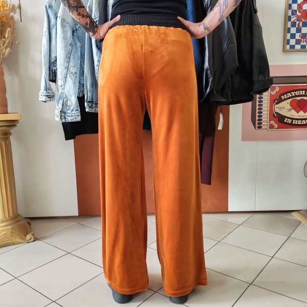 Pantalon velours orange vif avec ligne noir intense sur les côtés. 2 poches pratiques.