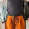 Pantalon velours orange vif avec ligne noir intense sur les côtés. 2 poches pratiques.