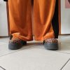 Pantalon velours orange vif avec ligne noir intense sur les côtés. 2 poches pratiques.