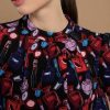 Robe imprimé motifs originaux Dernières Chances Mademoiselle Hélène Robe "Beauty Pop" de couleur noir tout en imprimés pop art. Motif beauté : parfums, lipsticks, poudriers, accessoires. Coupe fluide et confortabe, longueur au-dessus du genou. manches longues froncées, col légèrement froncé.