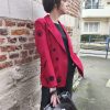 Blazer rouge épaules légèrement marquées. Motifs broderies noires (œil, cœur sacré, rouge à lèvres, diamant, revolver, rose, inscription " Ex-Wives Club). Tissu lisse et confortable, double rangée de boutons noires pour la fermeture, coupe ajustée.