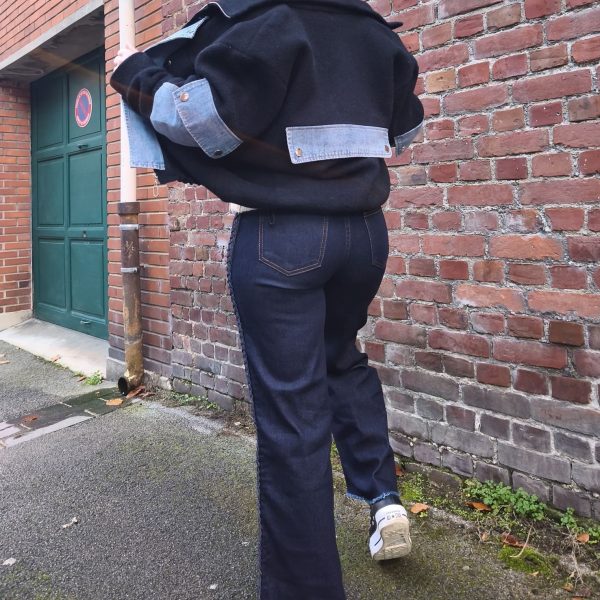 Jean large à tresses latérales, coupe droite et large, taille mi-haute, denim résistant et confortable, bouton + zip, bas légèrement effiloché.