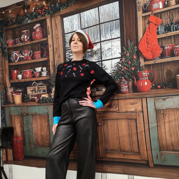 Pull "Guns & Glam" de couleur noir. Motifs brodés et imprimés : roses, rouges à lèvres, icônes pop art, bords-côtes contrastés, rose poudré à la taille, bleu vif aux poignets. Coupe féminine légèrement ajustée, maille douce et agréable.
