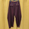 Pantalon taille haute bordeaux, taille haute structurée, coupe barrel et moderne, pinces à l'avant, poches plaquées à l'arrière, fermeture par bouton et zip.
