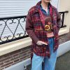 Veste matelassée carreaux brodée, liens latéraux pour ajustement, poches pratiques, col chemise structuré, rembourrage léger et confortable.
