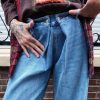 Jeans large taille haute denim bleu clair fermeture avec une patte de boutonnage croisé qui crée un effet asymétrique à la taille.