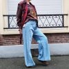 Jeans large taille haute denim bleu clair fermeture avec une patte de boutonnage croisé qui crée un effet asymétrique à la taille.