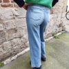 Jean barrel brodé love Jeans Mademoiselle Hélène Jean barrel brodé love, taille haute, denim clair délavé, broderies cœurs, fleurs et inscription, fermeture bouton + zip, longueur cheville / pleine longueur selon taille.