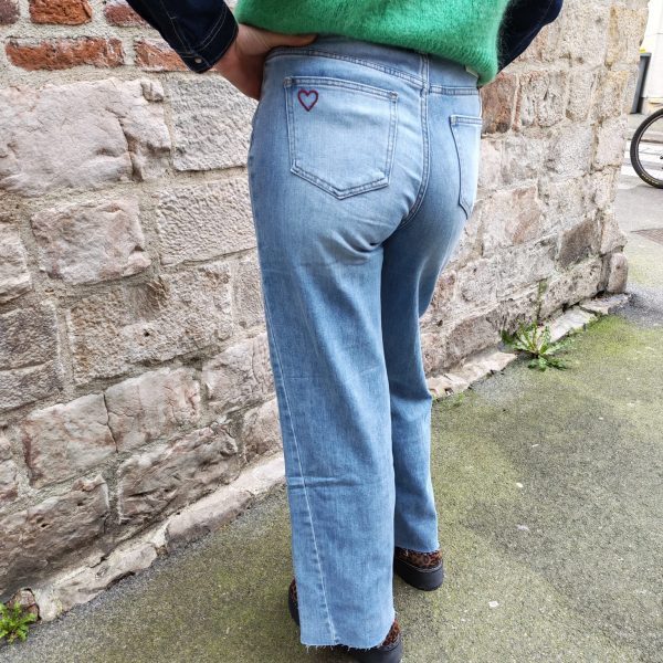 Jean barrel brodé love Jeans Mademoiselle Hélène Jean barrel brodé love, taille haute, denim clair délavé, broderies cœurs, fleurs et inscription, fermeture bouton + zip, longueur cheville / pleine longueur selon taille.