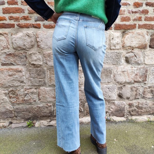 Jean barrel brodé love Jeans Mademoiselle Hélène Jean barrel brodé love, taille haute, denim clair délavé, broderies cœurs, fleurs et inscription, fermeture bouton + zip, longueur cheville / pleine longueur selon taille.