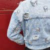 Veste en jean skull délavé, imprimé crânes, effet destroy avec détails usés, fermeture par boutons, poches poitrine avec rabat, coupe moderne et confortable, style rock.