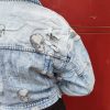 Veste en jean skull délavé, imprimé crânes, effet destroy avec détails usés, fermeture par boutons, poches poitrine avec rabat, coupe moderne et confortable, style rock.