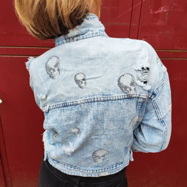 Veste en jean skull délavé, imprimé crânes, effet destroy avec détails usés, fermeture par boutons, poches poitrine avec rabat, coupe moderne et confortable, style rock.