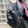 Veste simili cuir noire structurée, effet cuir texturé, coupe oversize, col montant avec boutons, fermeture zip frontal avec rabat asymétrique. Taille unique