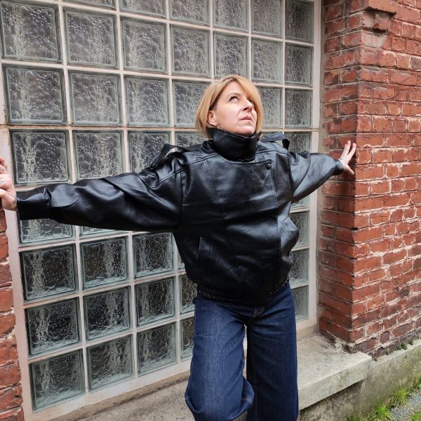 Veste simili cuir noire structurée, effet cuir texturé, coupe oversize, col montant avec boutons, fermeture zip frontal avec rabat asymétrique. Taille unique