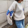 Pull papillon rayé doux Dernières Chances Mademoiselle Hélène Pull papillon rayé doux, papillons colorés sur les manches (bleu ou rouge), coupe oversize, maille douce, col rond, manches longues. Taille unique