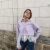 Chemise courte dentelle lilas, courte et légèrement ample, manches longues finitions dentelle, fermeture boutonnée sur le devant.