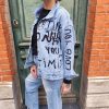 Veste jean graffiti message.Veste en jean Coupe oversize / décontractée Style streetwear, graffiti, street art Denim bleu clair délavé Inscriptions effet peinture noire Fermeture boutons métalliques 2 poches poitrine + poches latérales Denim robuste Veste customisé au design unique Composition : 95% coton, 5% polyester
