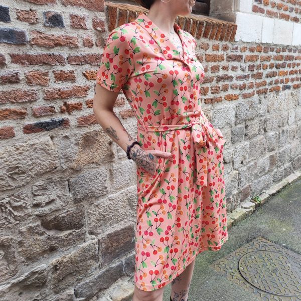 Robe imprimé cerises Hippocampe Robes / Combinaisons / Salopettes Mademoiselle Hélène Robe imprimé cerises Hippocampe . Marque Hippocampe (fabrication française) Robe fluide, ajustable à la taille Longueur au-dessus du genou Manches courtes Col décolleté en V Deux poches latérales Tissu fluide et léger Imprimé cerises all-over Lien à nouer sur le côté Coloris fond rose avec imprimé rouge et vert Style rétro, chic, estival Disponible du 38 au 44.