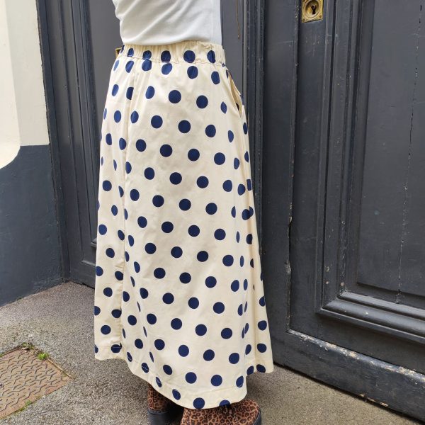 Jupe midi fluide pois.Jupe midi Fluide et évasée Légère et agréable à porter Taille élastique pour un maximum de confort Poches pratiques et discrètes Style jupe rétro chic, facile à associer Longueur midi (selon la taille) Coloris beige pois noirs, rose pois rouges, jaune pois noirs Idéale printemps/été Composition : 100% coton