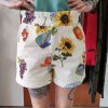 Short imprimé fruits vintage.Short imprimé fruits vintage Matière légère et agréable à porter Coupe fluide et décontractée Imprimé fruits & motifs vintage (tournesols, agrumes, raisins, sardines) Fermeture bouton + zip Poches latérales pratiques Poches arrière Facile à enfiler Idéal pour la saison estivale Composition : 100% coton