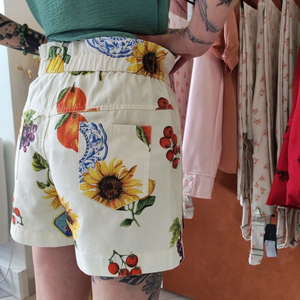 Short imprimé fruits vintage.Short imprimé fruits vintage Matière légère et agréable à porter Coupe fluide et décontractée Imprimé fruits & motifs vintage (tournesols, agrumes, raisins, sardines) Fermeture bouton + zip Poches latérales pratiques Poches arrière Facile à enfiler Idéal pour la saison estivale Composition : 100% coton