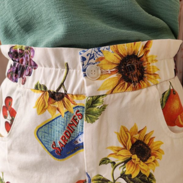 Short imprimé fruits vintage.Short imprimé fruits vintage Matière légère et agréable à porter Coupe fluide et décontractée Imprimé fruits & motifs vintage (tournesols, agrumes, raisins, sardines) Fermeture bouton + zip Poches latérales pratiques Poches arrière Facile à enfiler Idéal pour la saison estivale Composition : 100% coton