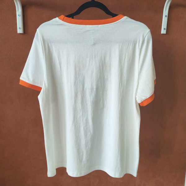 T-shirt orange brodé vintage Les hauts Mademoiselle Hélène T-shirt orange brodé vintage. T-shirt blanc avec détails orange contrastants Broderie orange et noire sur le devant Inscription "ORANGE - Pour Rome Italy" Manches courtes Col rond contrasté Coupe confortable Style rétro / vintage Matière douce et agréable à porter Taille normalement Facile à associer au quotidien Disponible en boutique et en ligne Livraison gratuite en France et en Belgique Retrait possible en boutique Les Curiosités Composition : 100% coton
