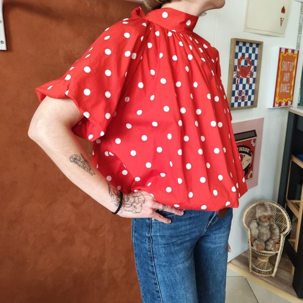 Blouse pois rétro chic Les hauts Mademoiselle Hélène Blouse pois rétro chic Blouse fluide à pois blancs Disponible en noir et en rouge Dos ouvert avec lien à nouer Col montant élégant Manches courtes amples Coupe fluide et confortable Style rétro chic et vintage Matière agréable à porter Facile à associer avec un jean, jupe ou pantalon taille haute Disponible en boutique et en ligne Livraison gratuite en France et en Belgique Retrait possible en boutique Les Curiosités Composition : 100% polyester