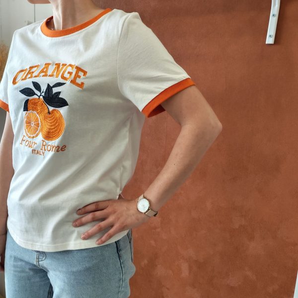 T-shirt orange brodé vintage Les hauts Mademoiselle Hélène T-shirt orange brodé vintage. T-shirt blanc avec détails orange contrastants Broderie orange et noire sur le devant Inscription "ORANGE - Pour Rome Italy" Manches courtes Col rond contrasté Coupe confortable Style rétro / vintage Matière douce et agréable à porter Taille normalement Facile à associer au quotidien Disponible en boutique et en ligne Livraison gratuite en France et en Belgique Retrait possible en boutique Les Curiosités Composition : 100% coton