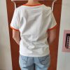 T-shirt orange brodé vintage Les hauts Mademoiselle Hélène T-shirt orange brodé vintage. T-shirt blanc avec détails orange contrastants Broderie orange et noire sur le devant Inscription "ORANGE - Pour Rome Italy" Manches courtes Col rond contrasté Coupe confortable Style rétro / vintage Matière douce et agréable à porter Taille normalement Facile à associer au quotidien Disponible en boutique et en ligne Livraison gratuite en France et en Belgique Retrait possible en boutique Les Curiosités Composition : 100% coton