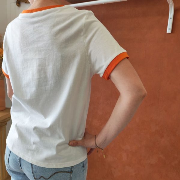 T-shirt orange brodé vintage Les hauts Mademoiselle Hélène T-shirt orange brodé vintage. T-shirt blanc avec détails orange contrastants Broderie orange et noire sur le devant Inscription "ORANGE - Pour Rome Italy" Manches courtes Col rond contrasté Coupe confortable Style rétro / vintage Matière douce et agréable à porter Taille normalement Facile à associer au quotidien Disponible en boutique et en ligne Livraison gratuite en France et en Belgique Retrait possible en boutique Les Curiosités Composition : 100% coton