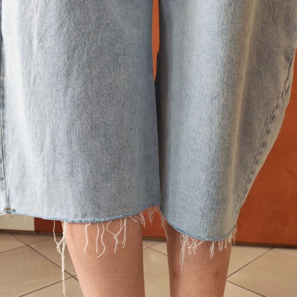 Bermuda barrel en jean. Coupe barrel Bermuda en jean Taille haute Coupe ample et confortable Coloris bleu denim clair Fermeture bouton et zip Lien à nouer à la taille 2 poches avant, 2 poches arrière Denim souple et agréable à porter Style casual & streetwear Facile à associer avec des baskets, boots ou sandales Disponible en boutique et en ligne Livraison gratuite en France et en Belgique Retrait possible en boutique Les Curiosités à Arras Composition : 70% coton, 29% tencel, 1% elastan